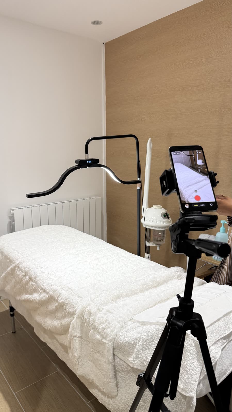Trépied et téléphone installés devant une table de soin