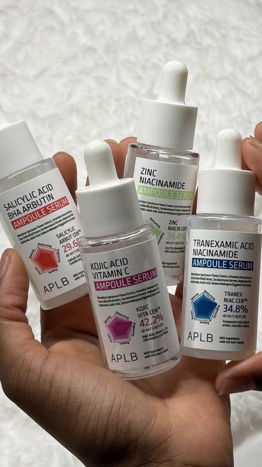 Quatre sérums en ampoule tenus en main
